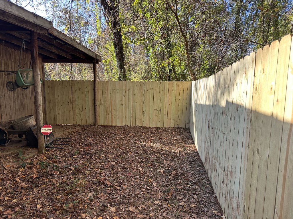 Privacy board fence with Compass Contracting sign