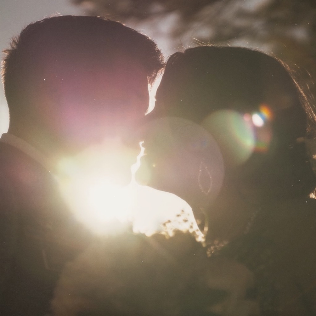 Couple silhouette sunset kiss with lens flare