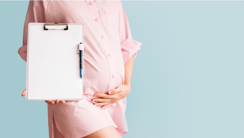Pregnant surrogate holding a clipboard