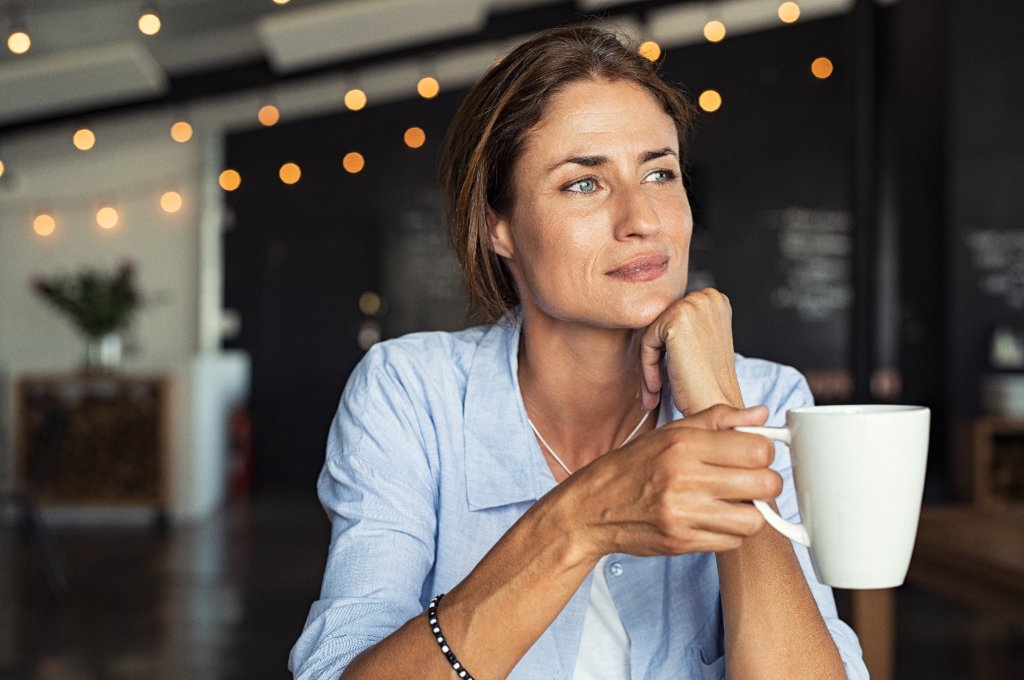 Thoughtful woman with coffee reflecting on fertility timing and age
