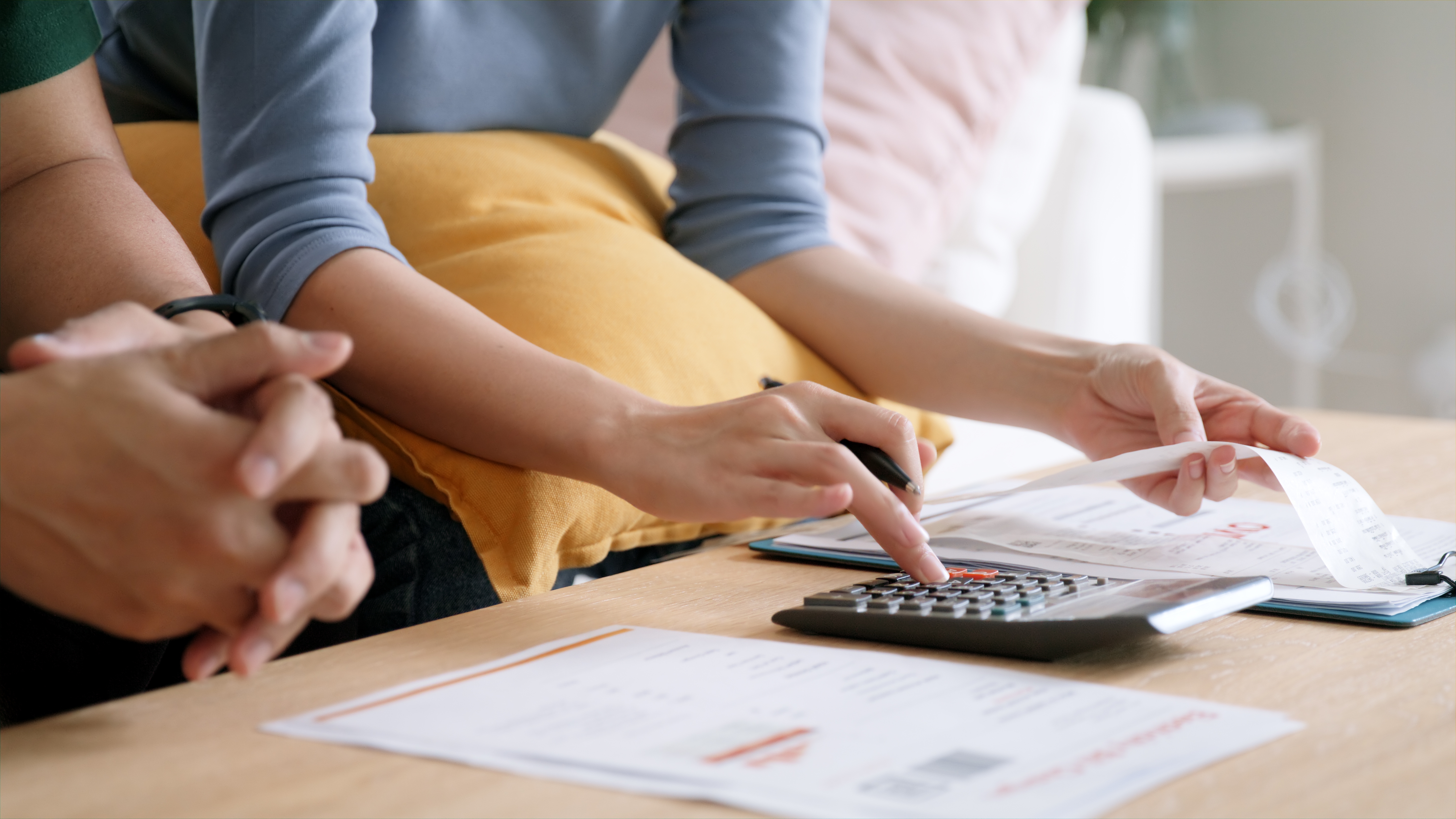 Couple working out the cost of IVF treatment with a calculator and clinic quotes