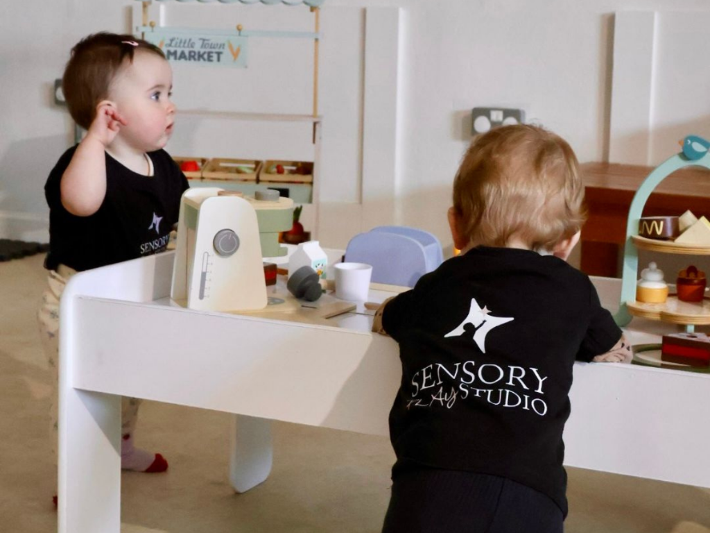 A warm sensory play environment with a parent and child exploring together
