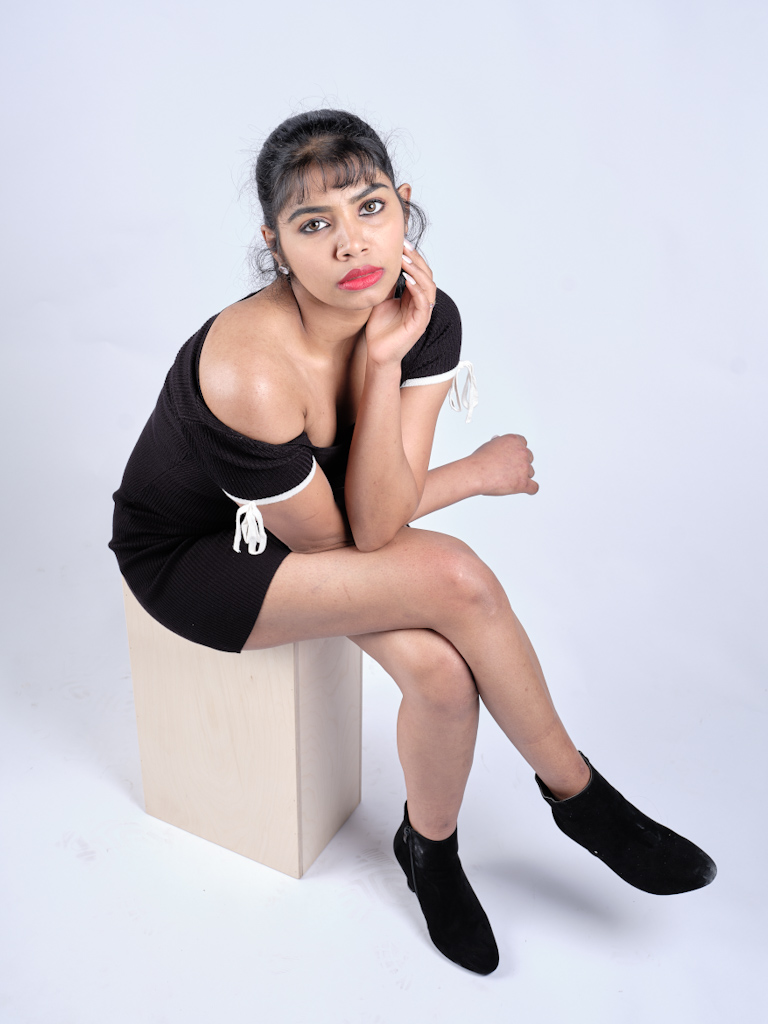 Seated woman in black off-shoulder dress