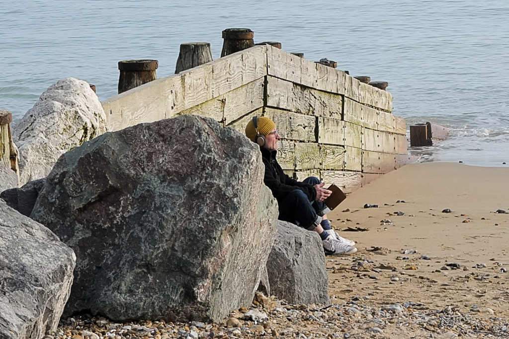 Person sitting on rocks at the beach