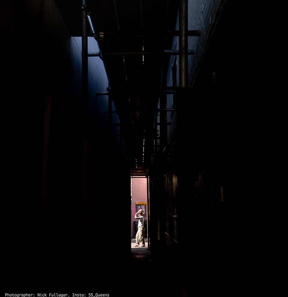 Dark alleyway with figure in light
