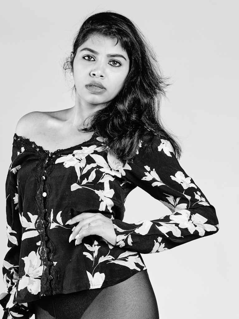 Black and white studio portrait in floral off-shoulder top