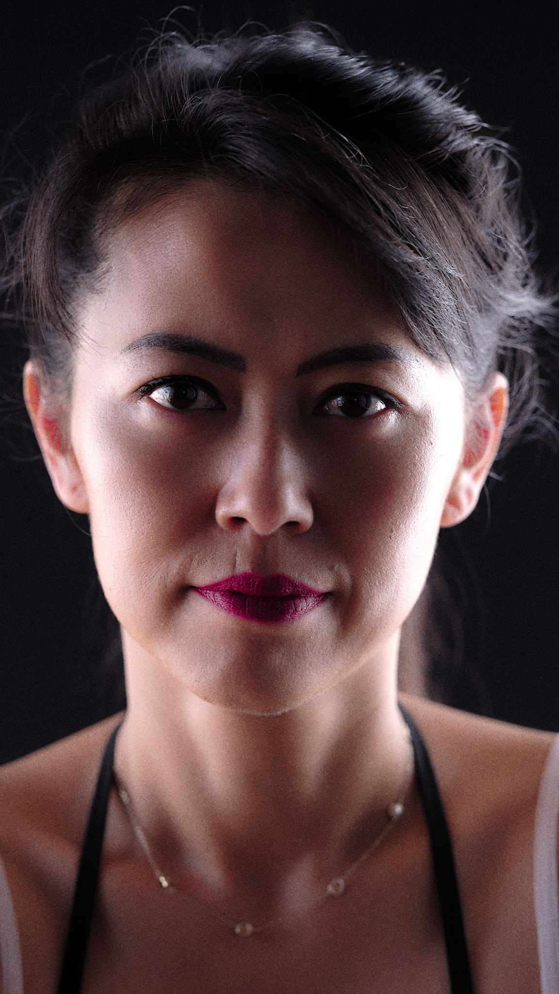 Dramatic studio portrait of woman with rim lighting against black background