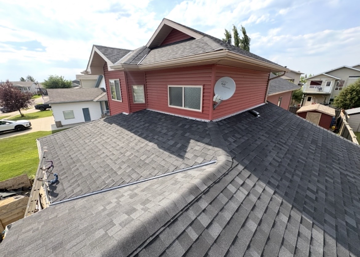 Dark grey architectural shingle roof with red-sided upper level