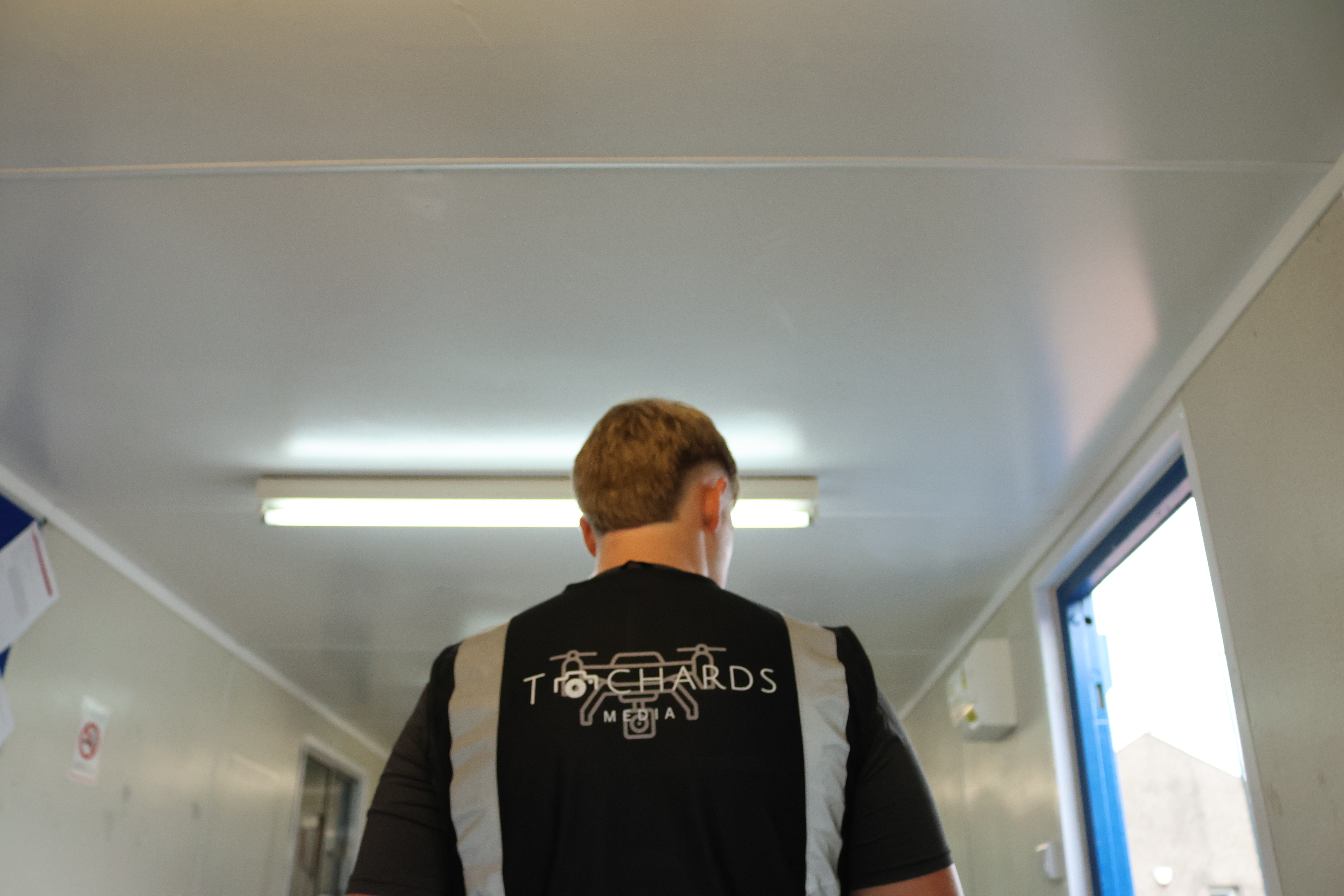 Tchards Media team member entering a site facility