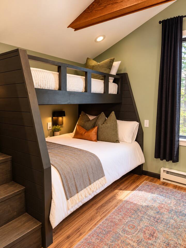 Bedroom with dark wood bunk bed and sage green walls
