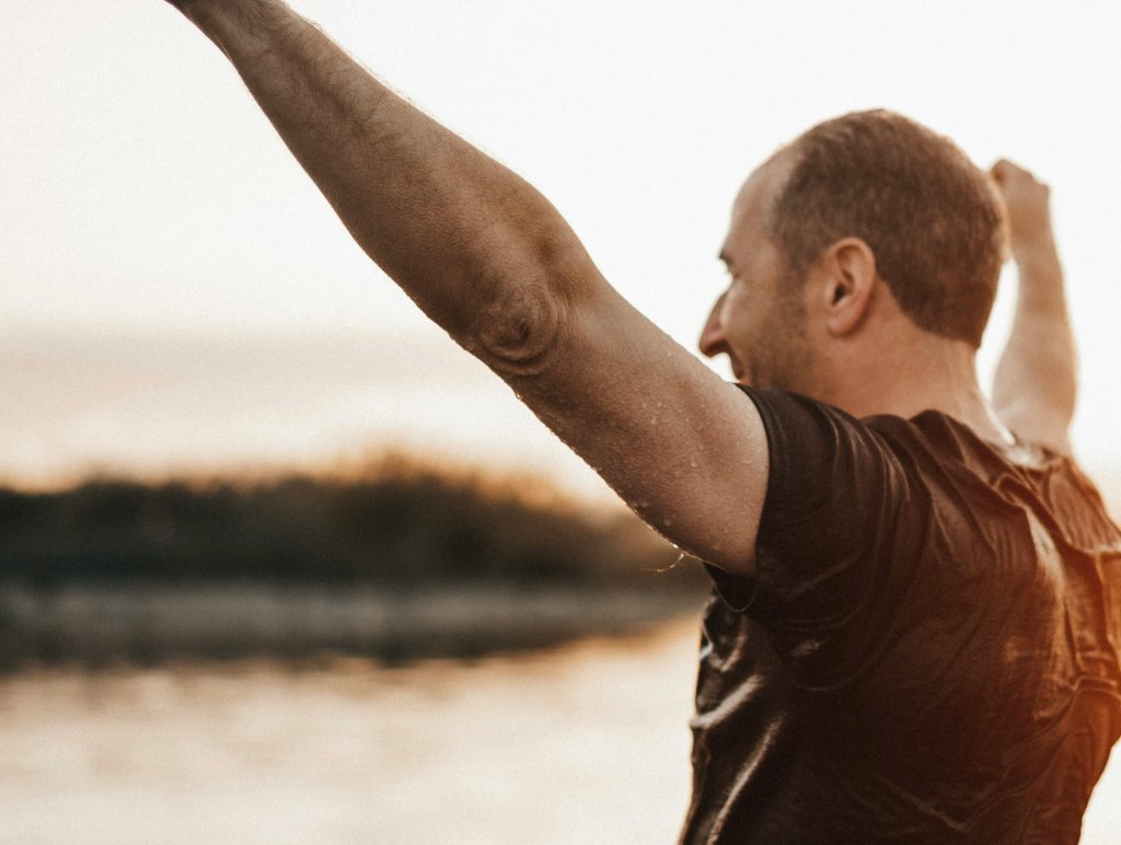 Man celebrating with fist pump at sunset
