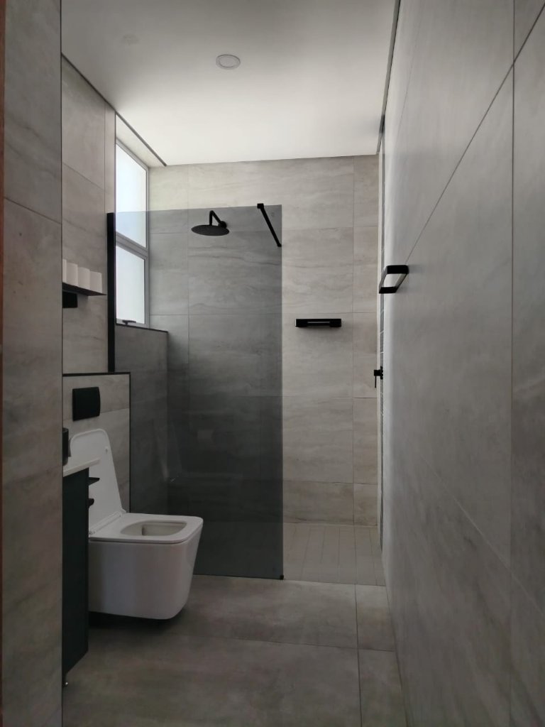 Luxury bathroom renovation with marble tiles and black fittings — OIKOS Construction