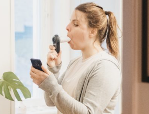 Patient measuring FEV₁ at home with the Air Next home spirometry device during a remote respiratory monitoring visit