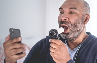 Patient performing a home spirometry test with the Air Next spirometer and a smartphone