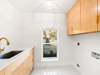 Modern utility room remodel with concrete sink, gold faucet, wood cabinets and white tile floor by 448 Developments in Dallas TX