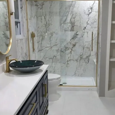 Modern bathroom remodel with frameless glass shower enclosure, large format grey tile, rain shower head and mosaic floor in Dallas TX