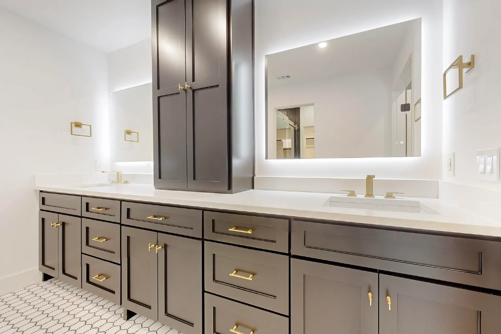 Master bathroom remodel with dark charcoal double vanity, white quartz counters, LED mirrors, geometric floor tile and gold knobs in DFW