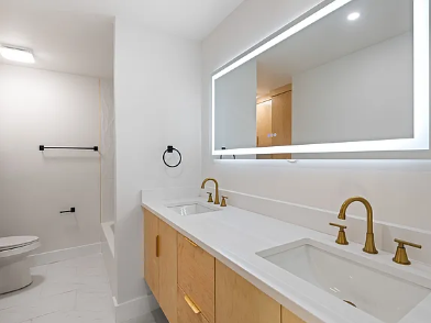 Bright white double sink bathroom vanity with marble quartz countertop, brushed gold faucets and square mirrors in a Dallas home