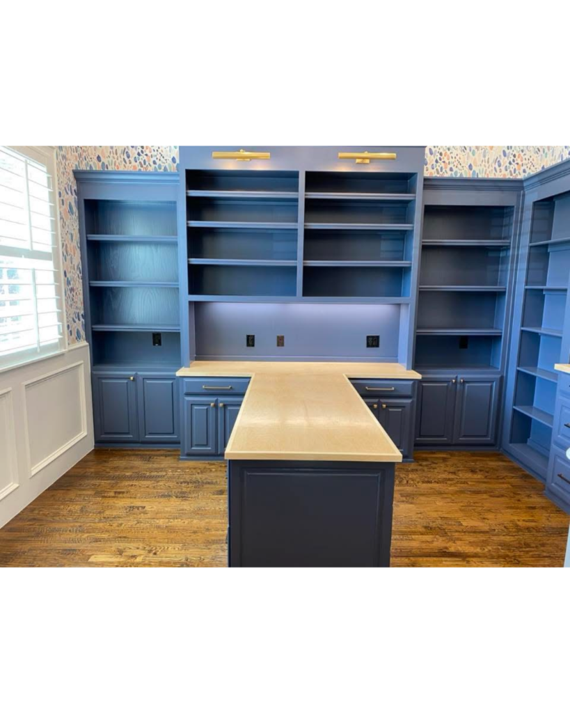 Blue painted built-in office shelving and cabinetry with center island desk by 448 Developments Dallas TX