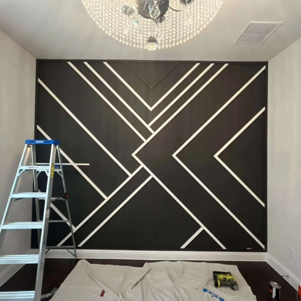 Bold geometric accent wall with black background and white intersecting lines and crystal chandelier by 448 Developments DFW