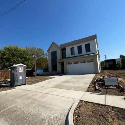 Freshly laid concrete driveway and sidewalk in front of a contemporary new-build home in the DFW area, emphasizing quality and modern curb appeal.