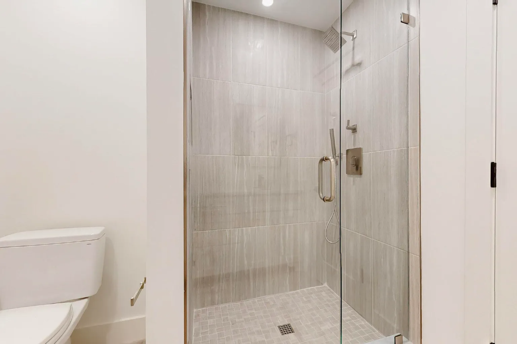 Bathroom remodel with frameless glass shower enclosure, freestanding oval soaking tub, black hexagon floor tile and matte black fixtures in Dallas