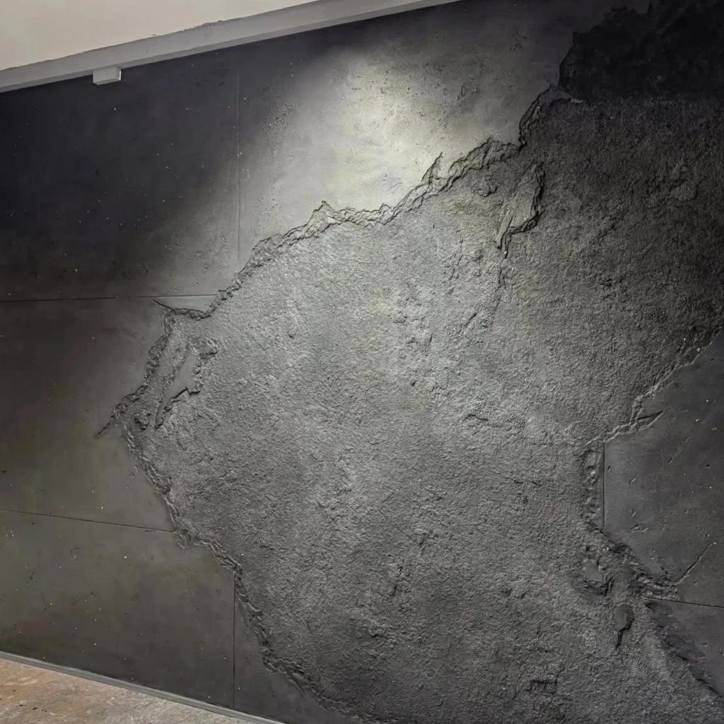 Unique accent wall with rough organic textured concrete finish resembling natural rock formation by 448 Developments Dallas TX