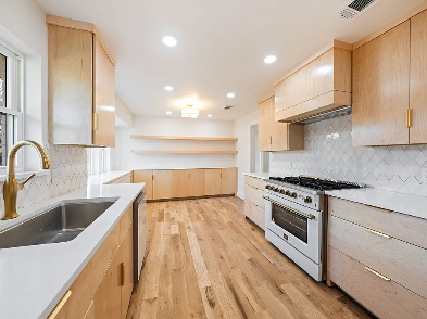 Custom kitchen remodel with light maple wood cabinets, white quartz countertops, herringbone backsplash and professional range in Dallas