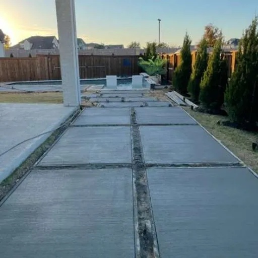 Newly poured residential concrete patio or walkway extension with clean, smooth finish, highlighting durable and aesthetic outdoor living space improvements in the DFW metroplex.