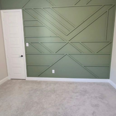 Bedroom with striking green geometric panel accent wall and white door in a modern minimalist aesthetic by 448 Developments DFW