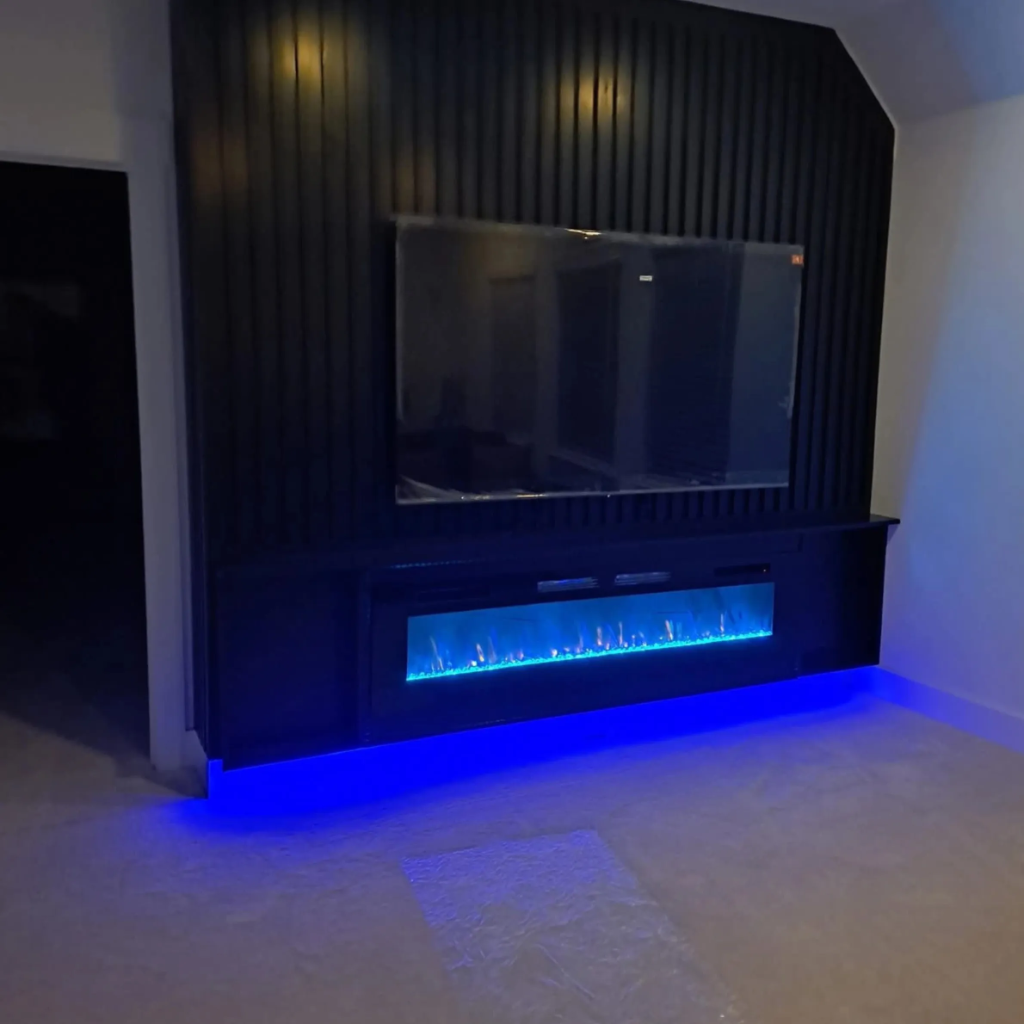 Interior accent wall with black vertical wood slats, mounted television, and electric fireplace with color-changing LED flames by 448 Developments Dallas TX