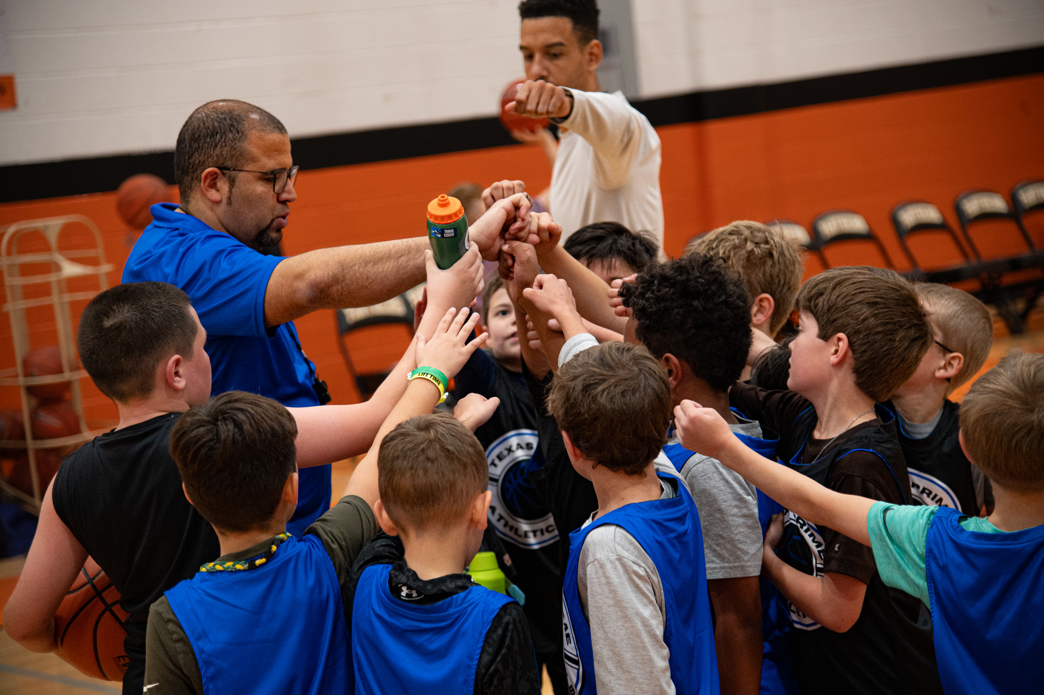 Texas Prime coach mentoring young basketball players during a practice session