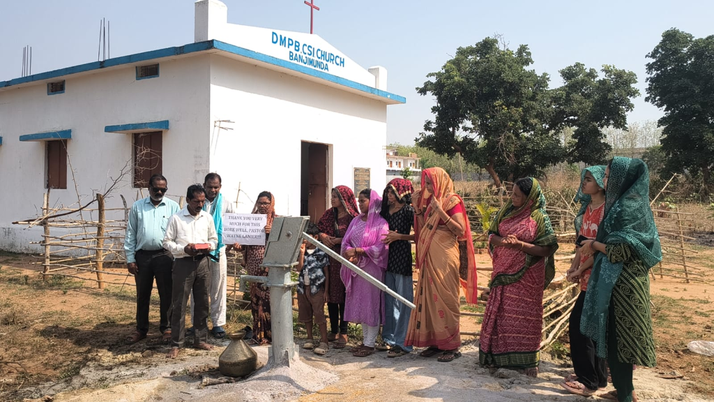 Completed bore well at DMPB CSI Church Banjimunda, India — community gathering around new clean water source