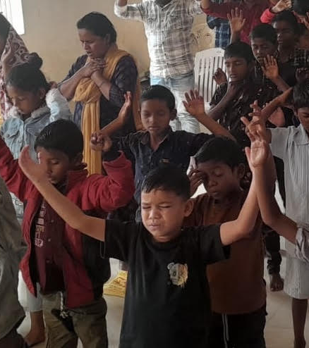 Children and staff in prayer at Caleb India campus in Kesinga, Odisha