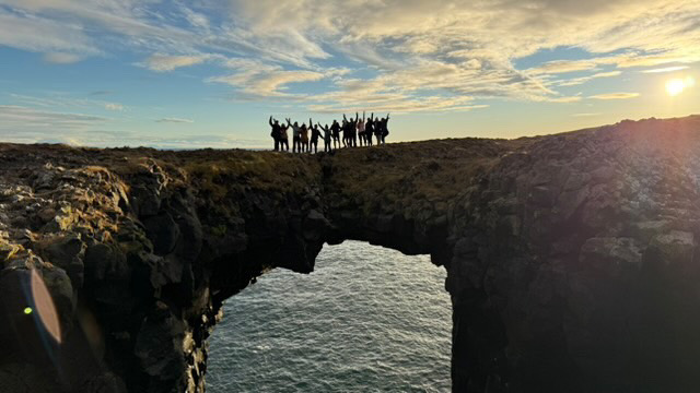 Group of adventurous people hiking at golden hour on a mountain trail