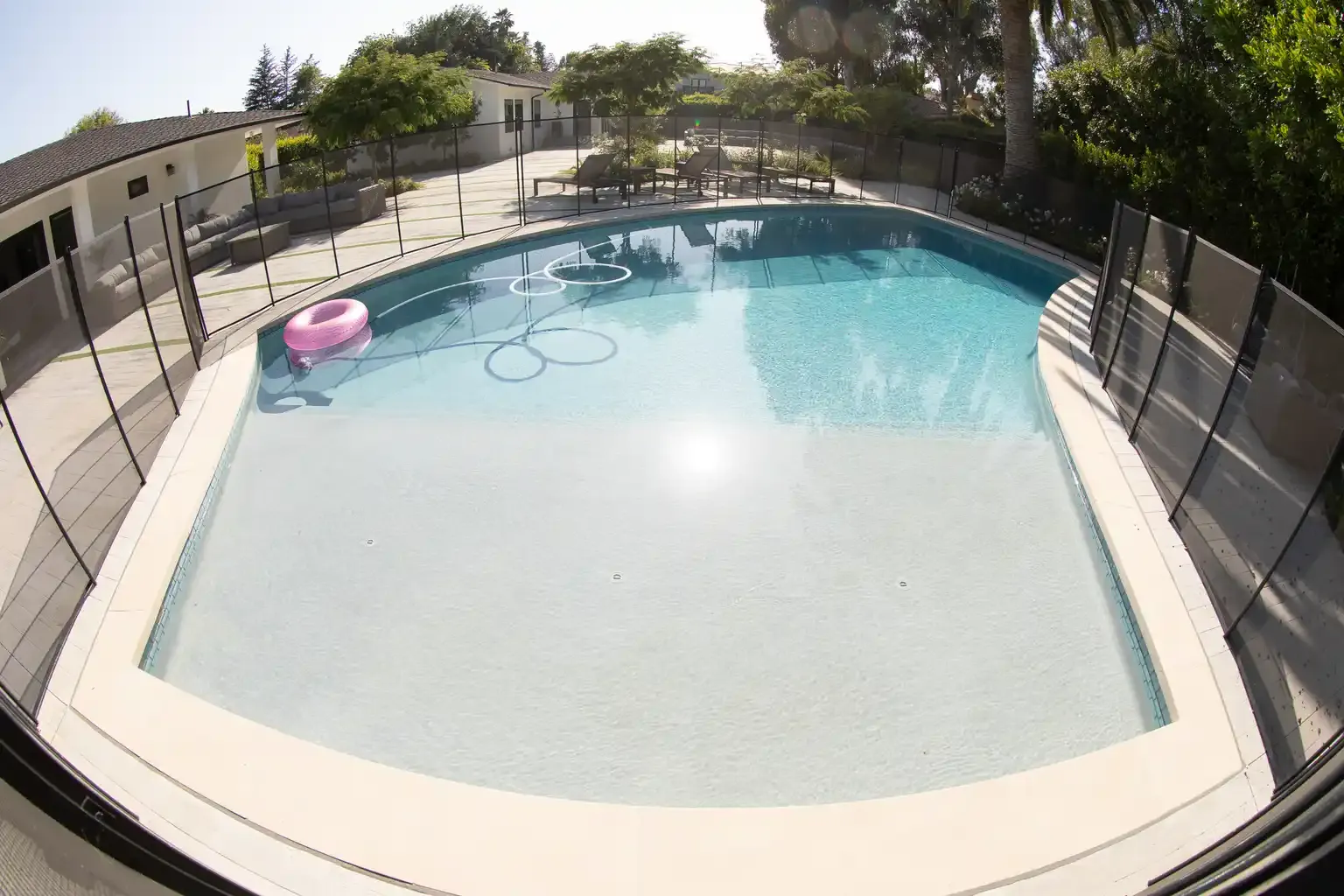 Crystal clear pool with lounge area and palm trees at men's sober living home Van Nuys CA — The Comeback SL
