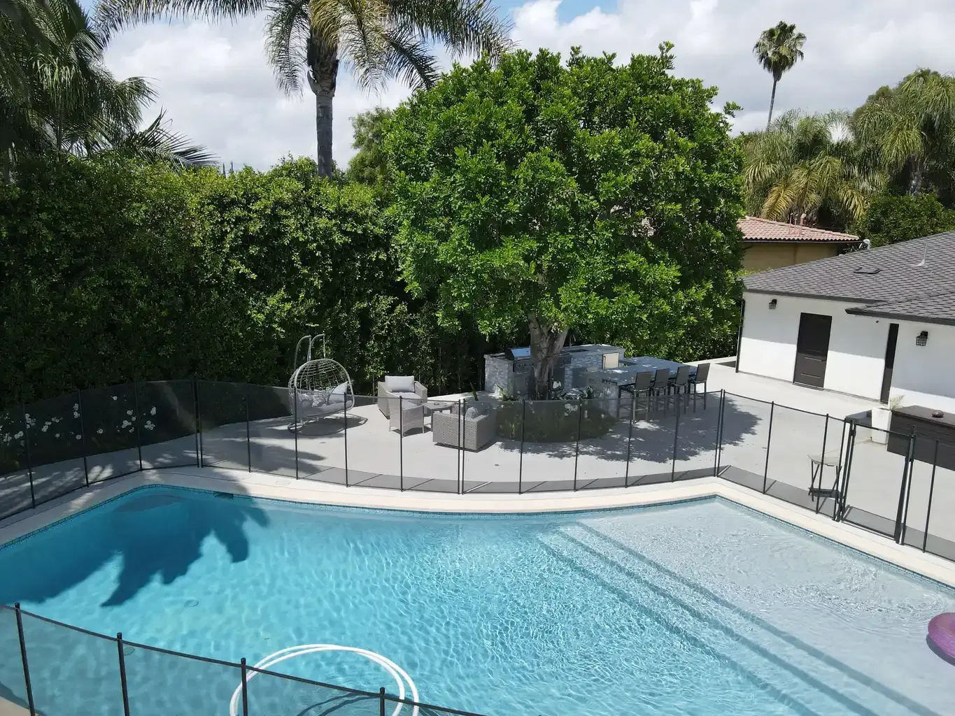 Pool and outdoor patio seating area with palm trees at men's sober living home Van Nuys Los Angeles — The Comeback SL