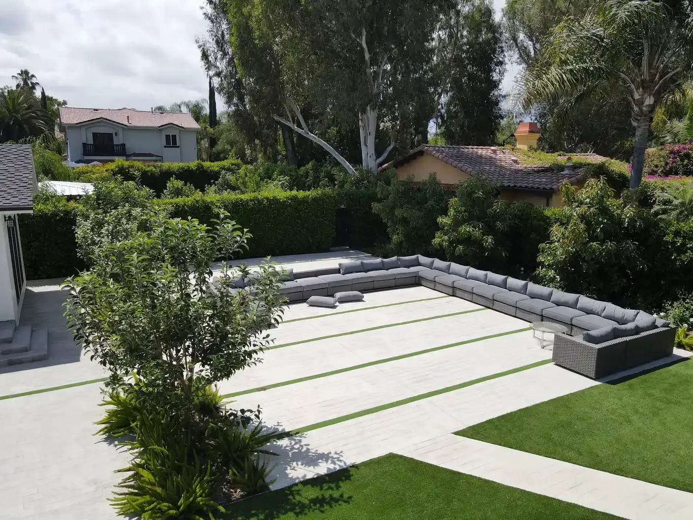 Large outdoor courtyard with U-shaped lounge seating and landscaped grounds at men's recovery home Van Nuys CA — The Comeback Sober Living