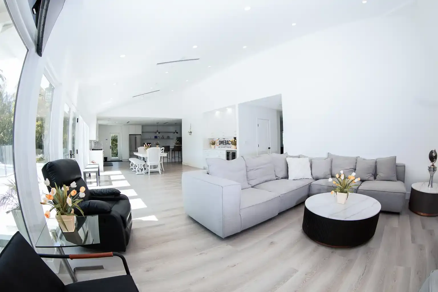Bright spacious living room with sectional seating and large windows at men's sober living home Van Nuys CA — The Comeback SL