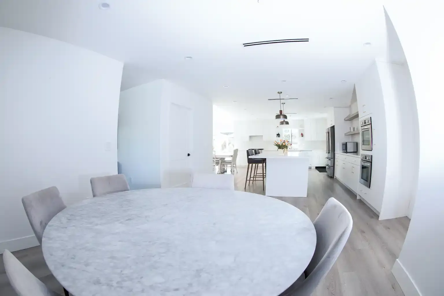 Dining area with marble table and open kitchen at structured sober living home in Van Nuys Los Angeles — The Comeback SL