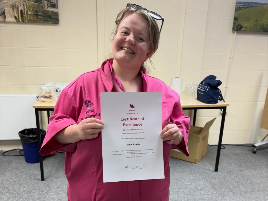 Jamie Scouler holding certificate of excellence
