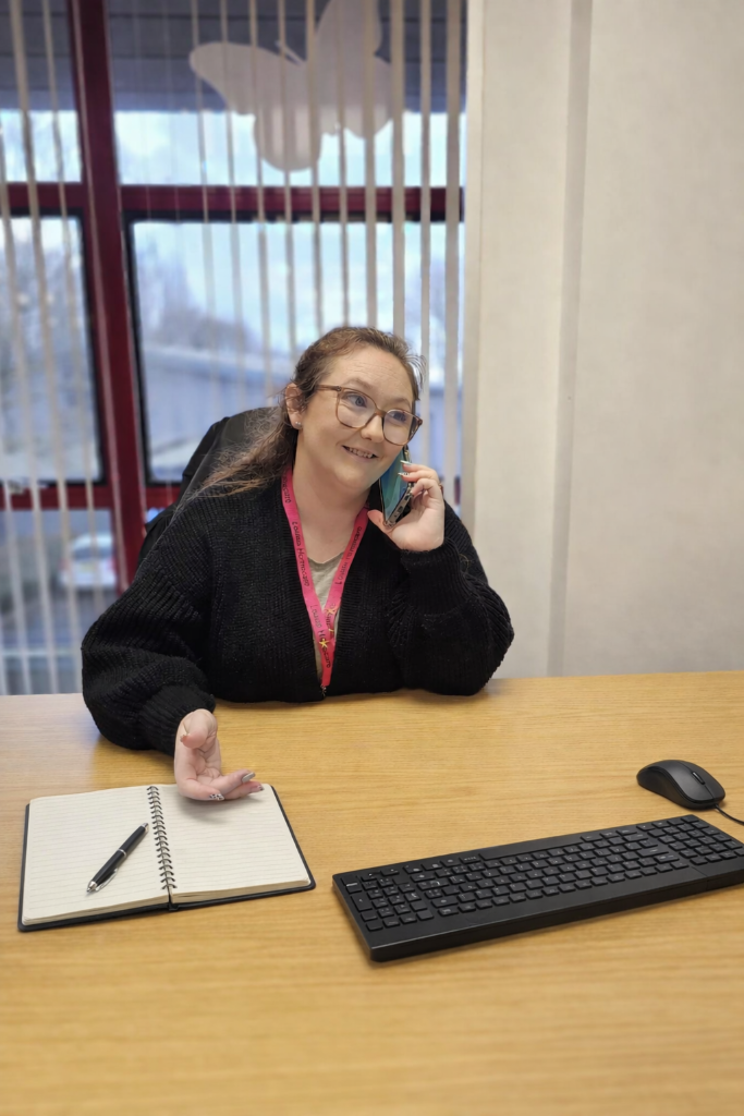 Lauren Weatherbed at her desk on the phone