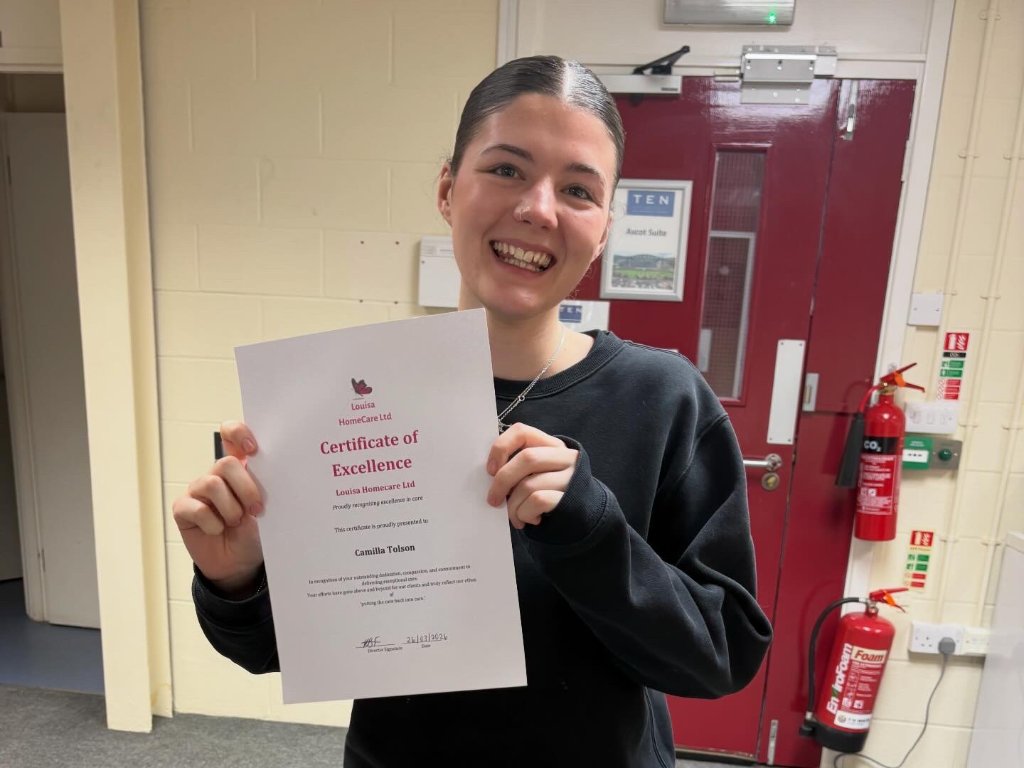 Camilla Tolson holding certificate of excellence