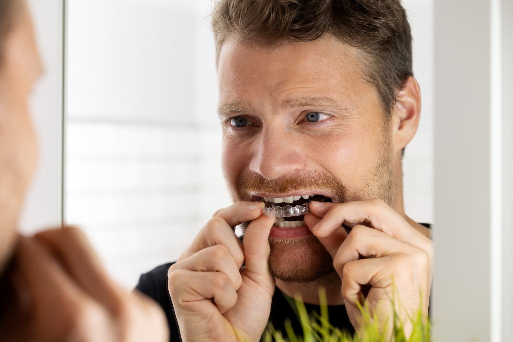 Voksen mann med usynlig tannregulering