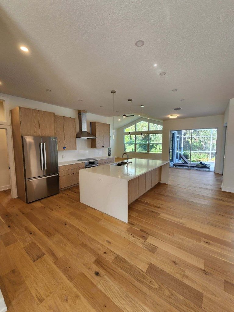 Kitchen with natural hardwood flooring and light cabinetry