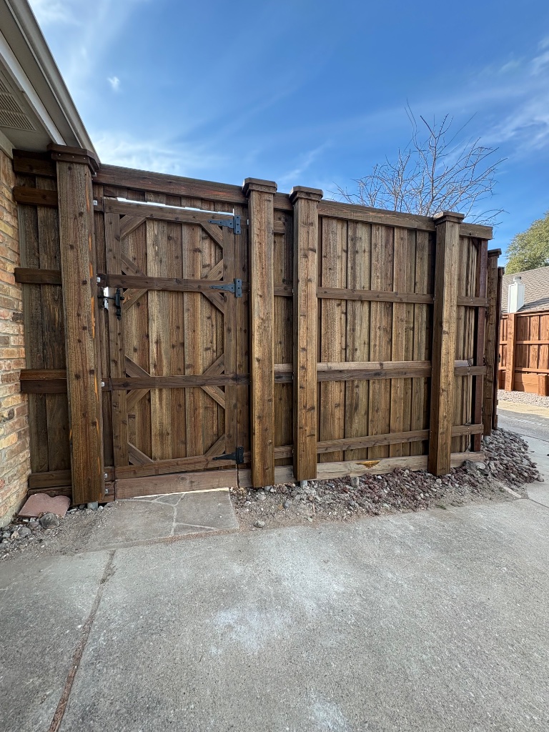 Custom cedar wood double gate with decorative cross-bracing and dark stain finish