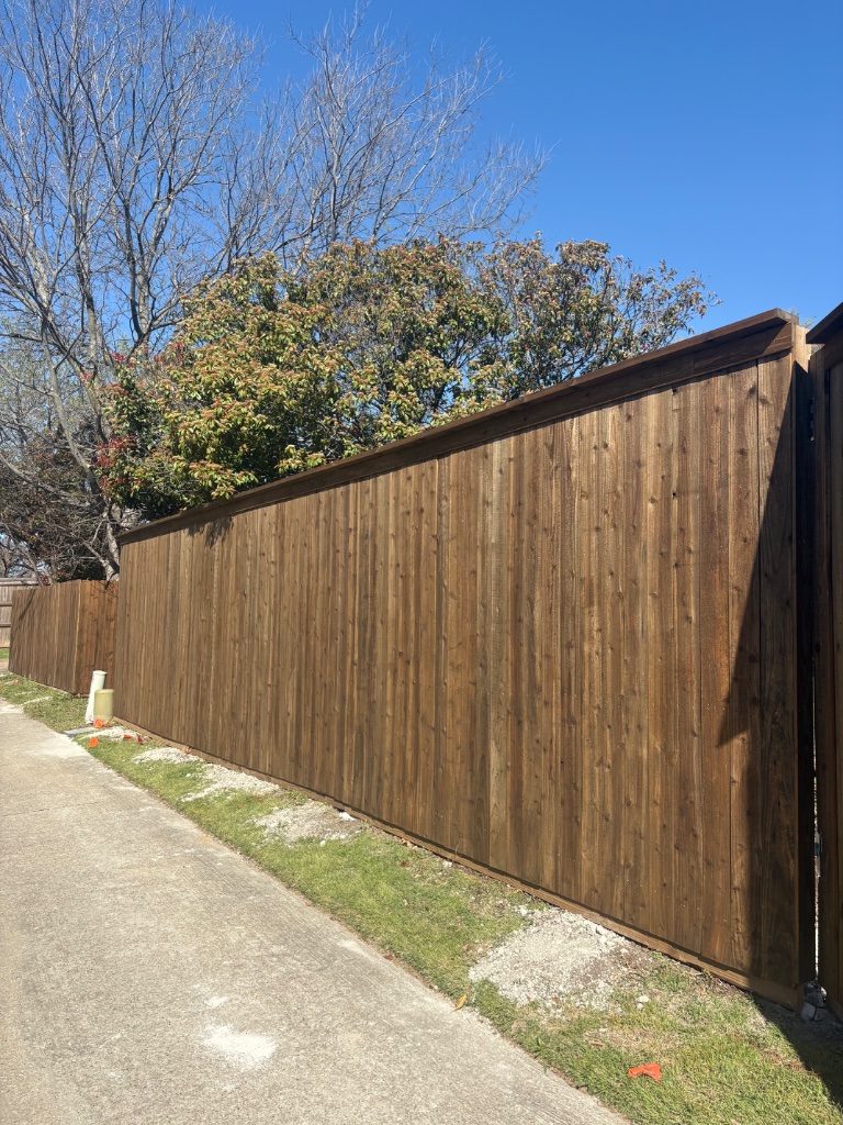 Cedar privacy fence with rich dark stain and clean board construction along property line