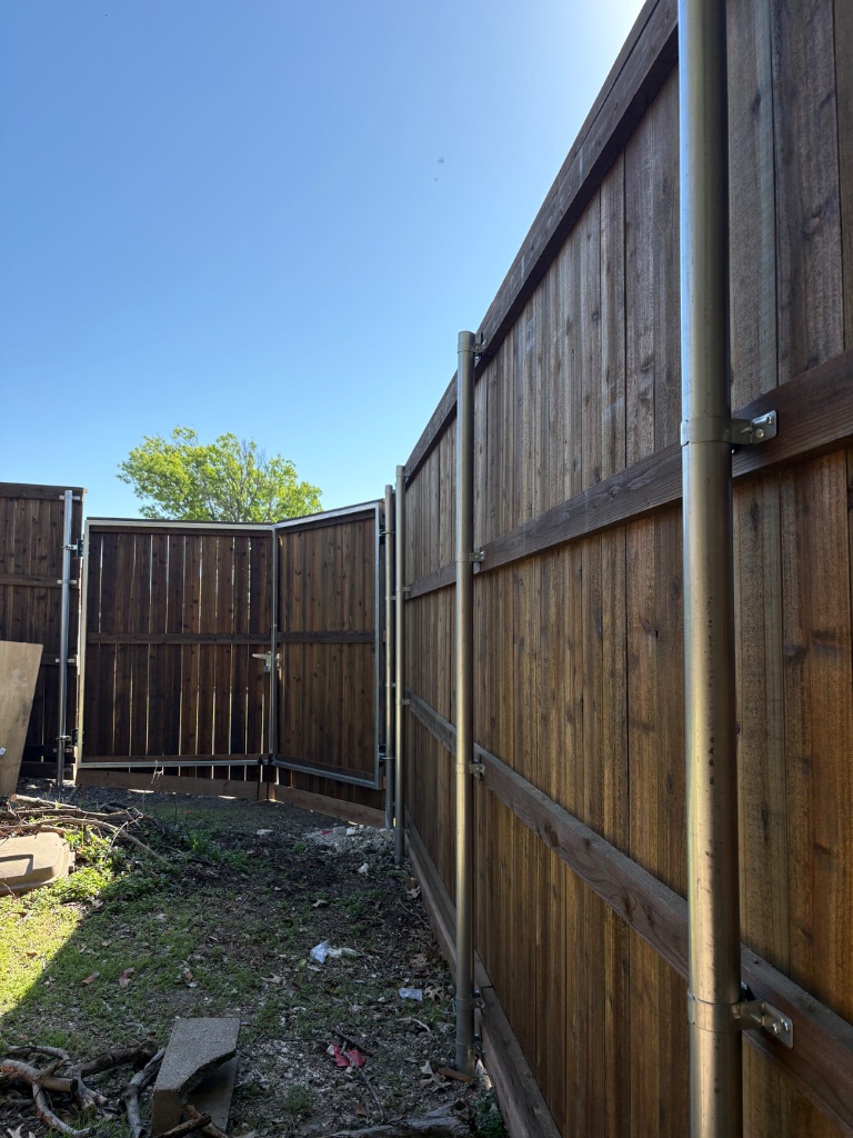 Cedar wood fence panels with metal post framing and open gate view