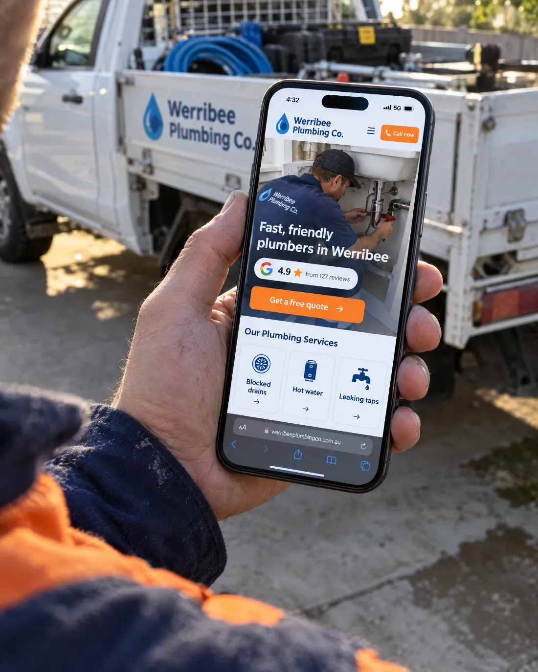 Tradie holding a phone showing a mobile plumbing website