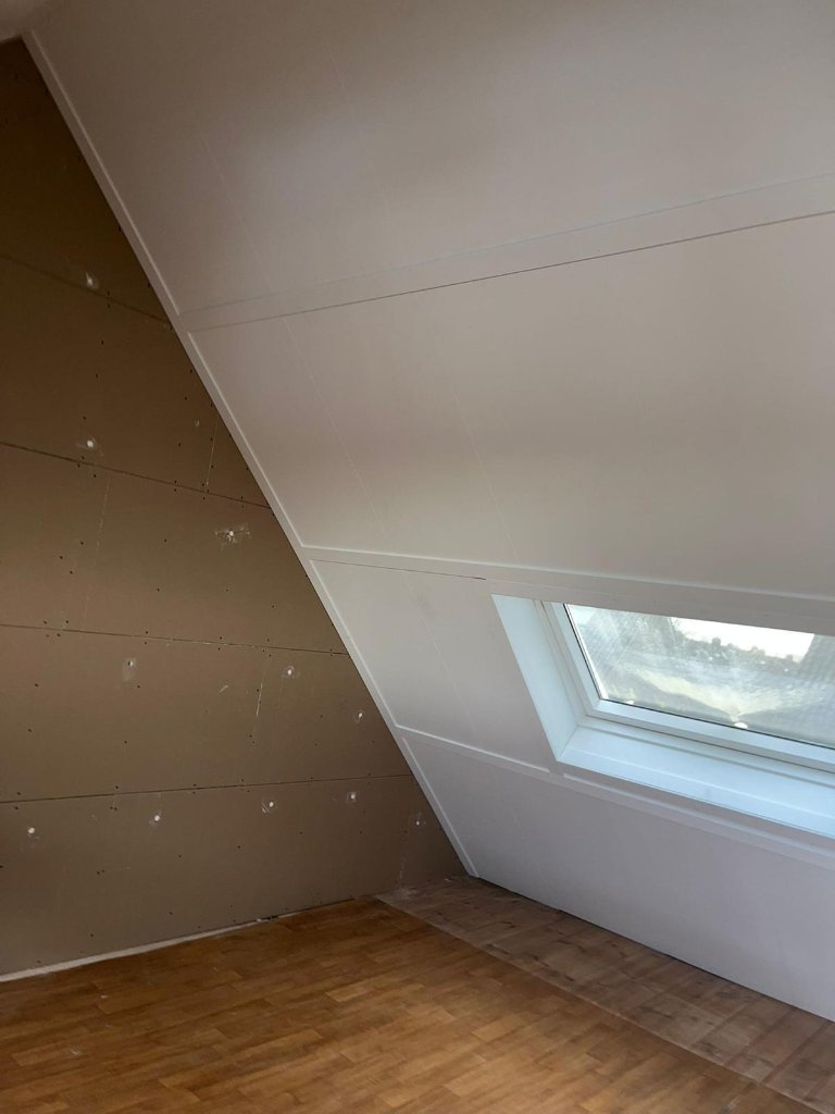 Afgewerkte zolderhelling met witte panelen